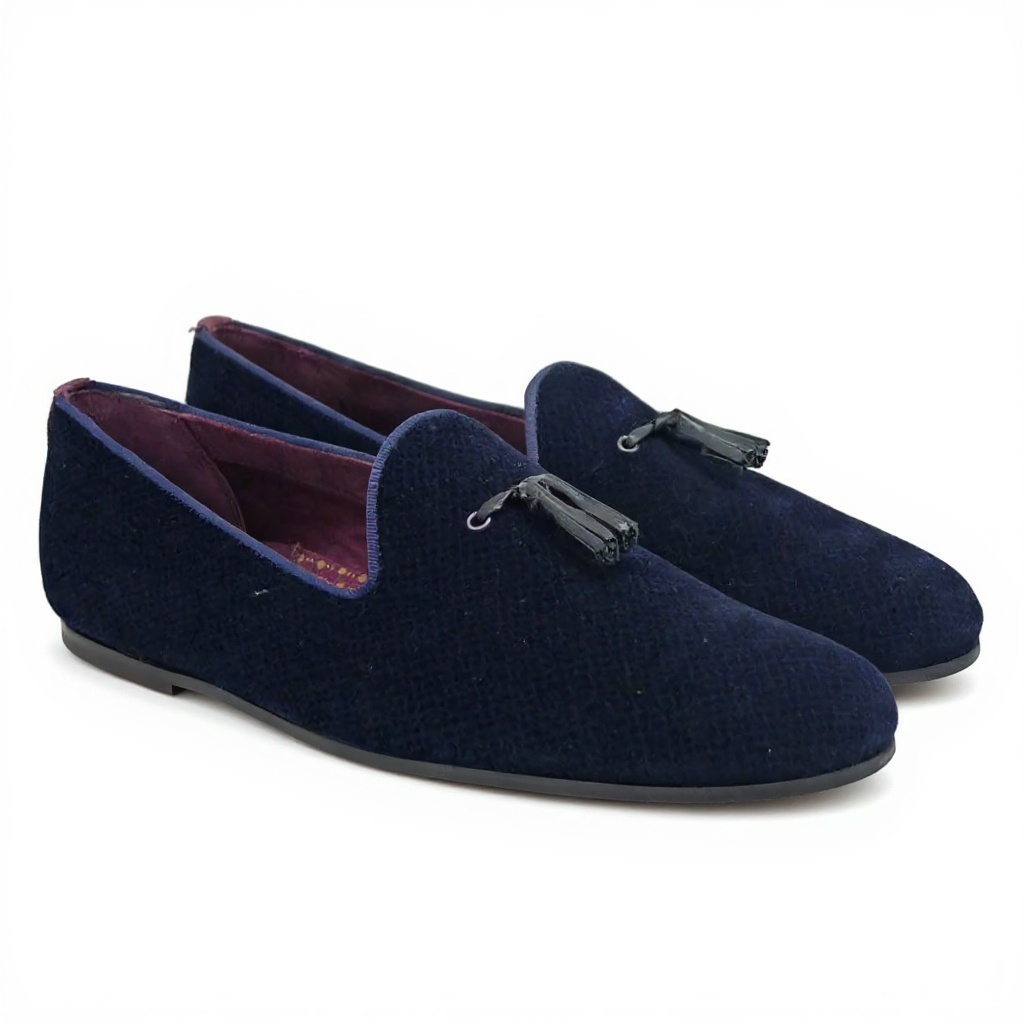Vista detallada del slipper TED BAKER azul, mostrando la suave textura de terciopelo, el interior de piel genuina y la construcción de la suela, resaltando la calidad de los materiales.